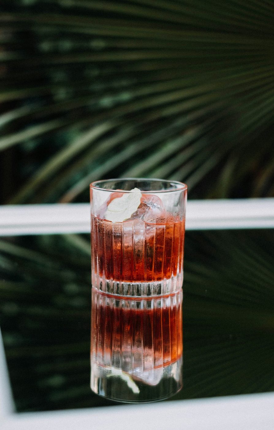 Red cocktail against a palm backdrop — Les Verseurs mobile bar Montreal